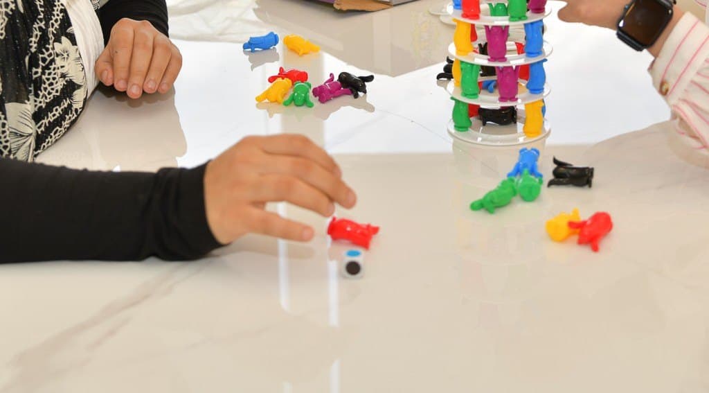 Hands during a session at a work table with coloured materials